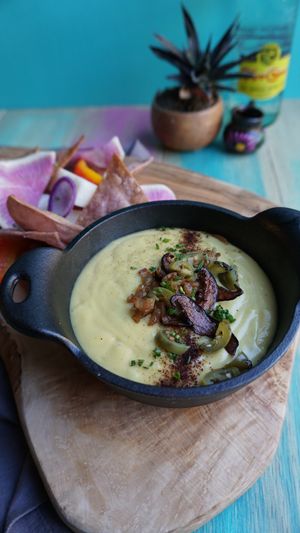 Queso Blanco 

Silky queso blanco topped with griddled onion, pickled peppers and shiitake bacon. Served with crispy blue corn chips, jicama, bell pepper, and radish for dipping! at Vegan Chula at 51 & Tel in Oakland