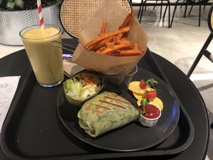 Mango-peanut butter smoothie, smoked tofu wrap and sweet potato fries  at Veg Stop in Riga