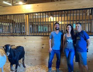 Sweet Farm co-founder Nate Salpeter (closest to the happy goat) at Sweet Farm in Himrod