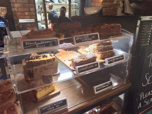 Cake counter - the two top rows (noted VE) are vegan at The Cosy Cafe in Hay-on-wye