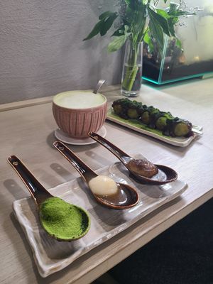Miso dango in spoon/ matcha & anko cakes in background at Cafe Chairo in Tokyo