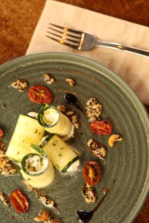 Rolls de calabacín y feta con tomate cherry asado, aderezo de dátiles y miel de semillas at Baobab Soul Kitchen & Bar in Alicante