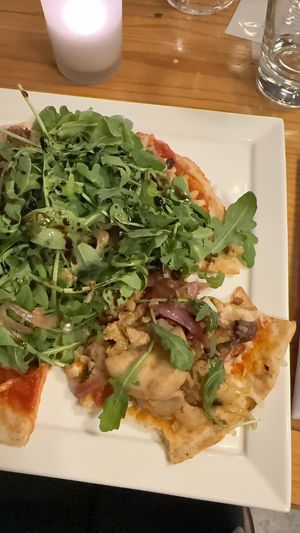 Pizza is stacked with vegetables  at Candle in New York City