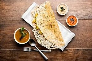 Rava Dosa, a thin and crispy crepe made from rava, rice flour, semolina and cumin. Served with sambar, coconut and tomato chutney. at Jagdish Farshan in Irving