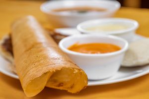 Dosa is a crispy and savory South Indian pancake made with a fermented batter of rice and lentils, typically served with chutneys and sambar. at Jagdish Farshan in Irving