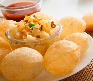 Pani puri, also known as golgappa, is a popular Indian street food made of crispy hollow dough balls filled with spiced mashed potatoes and served with a tangy tamarind or mint water for dipping. at Jagdish Farshan in Irving