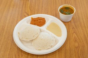 Idli is a popular South Indian breakfast dish made with a fermented batter of rice and lentils, steamed until soft and fluffy, and served with chutney and sambar. at Jagdish Farshan in Irving