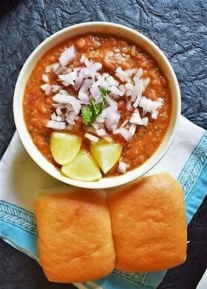 Pav bhaji is a popular Indian street food consisting of a spicy vegetable curry (bhaji) served with a soft bread roll (pav), often garnished with onions, coriander, and a squeeze of lime. at Jagdish Farshan in Irving