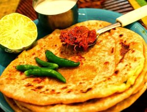 Aloo Paratha is a most loved flatbreads made with whole wheat flour, mashed potatoes, spices & herbs. at Jagdish Farshan in Irving