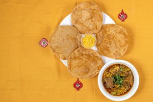 Undhiyu Puri is a traditional Gujarati meal consisting of Undhiyu (mixed vegetable curry), Puri (deep-fried Indian bread). at Jagdish Farshan in Irving