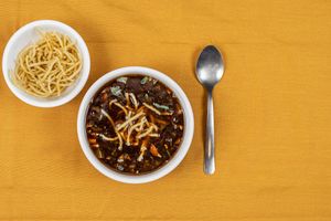 Manchow soup is a spicy and flavorful Indo-Chinese soup made with mixed vegetables, noodles, and a blend of spices, often served with fried noodles or croutons on top. at Jagdish Farshan in Irving