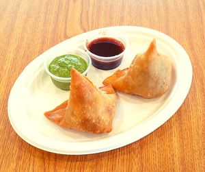 Samosa is a popular Indian snack consisting of a crispy pastry shell filled with spiced potatoes, peas, or meat. at Jagdish Farshan in Irving