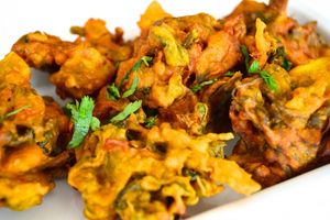 Mix veg pakoda is made by  mixing variety of vegetables such as onion, potato, and spinach with a spiced gram flour batter and deep-frying until crispy and golden brown. at Jagdish Farshan in Irving