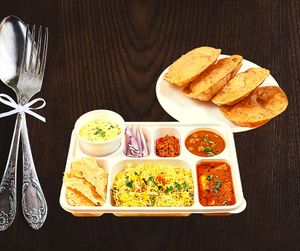 Punjabi Thali is a North Indian meal that has a variety of dishes including dal makhani, chole, paneer butter masala, naan bread, rice, and various sides, served on a large platter at Jagdish Farshan in Irving
