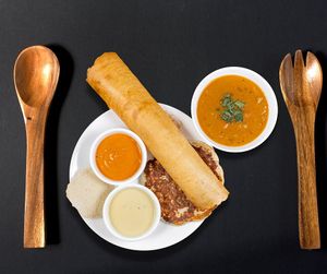 A South Indian thali includes a small uttapam, a Dosa, and one idli along with sambhar, tangy tomato chutney, and peanut chutney. at Jagdish Farshan in Irving