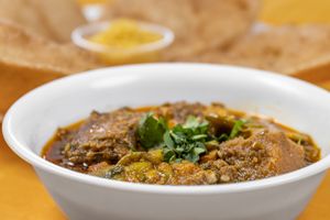 Undhiyu is a popular Gujarati mixed vegetable dish made with a variety of seasonal vegetables, spiced chickpea dumplings, and coconut, simmered with a blend of spices. at Jagdish Farshan in Irving