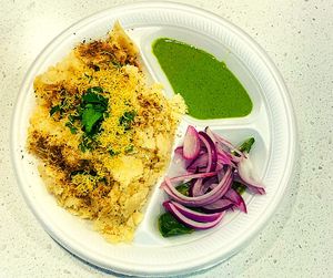 Surti Locho is a popular Gujarati street food made with a batter of rice flour, gram flour, and chana dal, fermented overnight, steamed, and topped with sev, onions, and chutney. at Jagdish Farshan in Irving