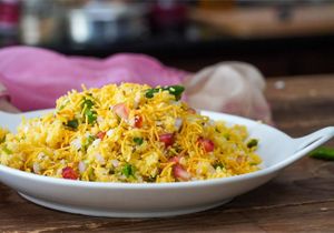 Sev Khamani is a popular Gujarati snack made with crumbled and tempered dhokla, topped with sev, onions, and chutney. at Jagdish Farshan in Irving