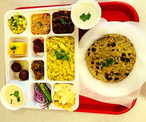 Kathiyawadi Thali is a traditional Gujarati meal, consisting of a variety of spicy vegetarian dishes such as bajra roti, ringan no olo, sev tamatar, and  and chaas. at Jagdish Farshan in Irving