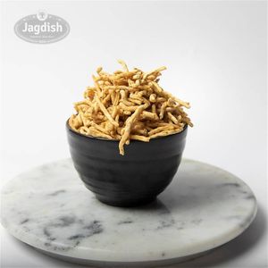 Ratlami sev is a spicy and crispy snack made with gram flour, flavored with a blend of spices including black pepper, cumin, and clove, and deep-fried until golden brown. at Jagdish Farshan in Irving