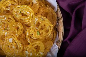 Jalebi is a popular Indian sweet made by deep-frying a fermented batter of wheat flour, which is then soaked in sugar syrup, resulting in crispy and syrupy spiral-shaped delicacy. at Jagdish Farshan in Irving