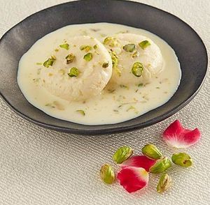 Rasmalai is a popular Bengali dessert made with spongy cottage cheese balls soaked in sweetened milk, flavored with cardamom, saffron. at Jagdish Farshan in Irving