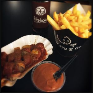 Scalded organic bratwurst in spicey sauce and fries at Curry Co in Leipzig