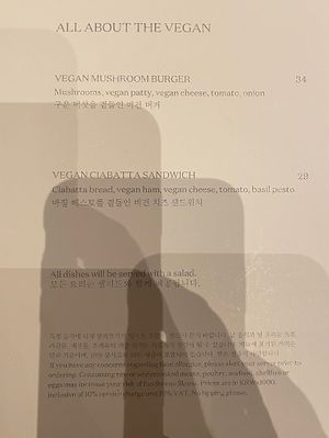Very poor photograph of the vegan menu.  It says:  Vegan Mushroom Burger and Vegan Ciabatta Sandwich   at Cafe One -  JW Marriott Seoul in Seoul