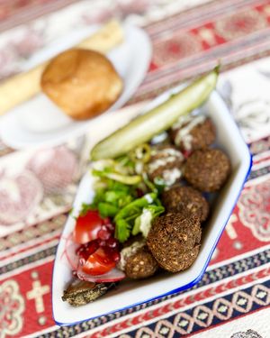 Jengyalofel (falafel + jengyalov hac herbs) with baked eggplant, tahini sauce, herbs, pomegranate, radish and radish tops, cherry tomato, marinated Armenian jalapeno, pickles at 2022_bak in Yerevan