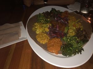 Feast for 2 with injera bread with some ambient lighting at Bunna Cafe in Brooklyn