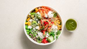 Mixed leaves, white and black quinoa, carrots, green peas, cherry tomatoes, corn, peppers, cucumbers, feta, salsa criolla and microgreens Dressing: pesto at GOVINDA in San Gwann