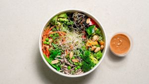 Rice noodles, snap peas, broccoli, carrots, bell peppers, marinated mushrooms, peas, avocado, peanuts, green onions and microgreens. Dressing: sesame, peanuts, ginger and tamari at GOVINDA in San Gwann