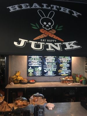 The front of the restaurant. It’s inside a building with big letters on the front that say, “Good Food”. at Healthy Junk in Anaheim