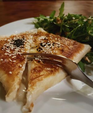the 'feta me meli' - phyllo pastry with vegan feta melted inside, topped with a sweet & smoky glaze, and an arugula side salad at VÜMO in Porto