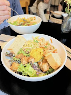 Rice noodle and carrot, peanut satay tofu, green salad, and edamame salad with bread and dip  at salarte in Munich