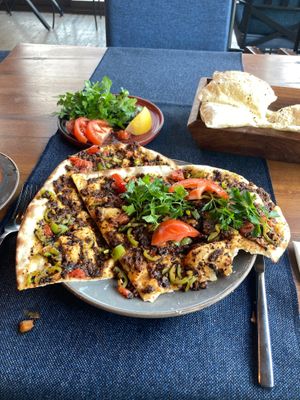 The serve you the pizza plus a side dish of lemon, parsley, and tomato to add to it. Amazingly flavorful! at Köşebaşı  in Goreme
