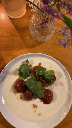 Starter August 2023: homemade soy yoghurt with oven baked tomatoes and coriander. The tomatoes were so flavorful and perfectly balanced by the cold soy yoghurt  at Tonka in Frankfurt