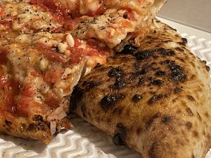 Calzone (stuffed with vegan mozzarella, deep-fried aubergines and mushrooms) and vegan margherita topped with friarielli, black olives and bell peppers   at Sacro Dough Pizza in North West London