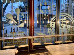swings to sit on at the bar, looking out at the street  at Fresh Burritos in Paris