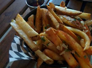 Side of fries, with fresh garlic & parsley at Hella Vegan Eats in Oakland