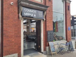 Door and facade of the board game cafe, featuring a pride flag at Common Meeple Board Game Cafe in Swansea