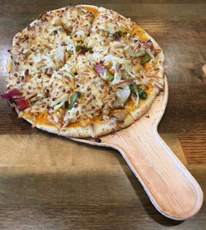 Roasted Potato & Veggie Signature Pizza, on a compostable disposable serving plate. Tandoor-fired crust was nice and crispy. Harissa habanero sauce adds the right amount of heat. at Pizza Karma in Apple Valley