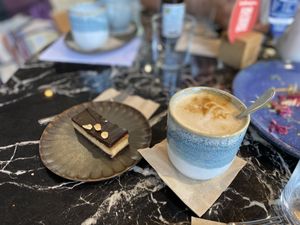 Chocolate-peanut slice and oat cappuccino   at Organic Garden Eatery - Studio Odeonsplatz by Mercedes-Benz  in Munich