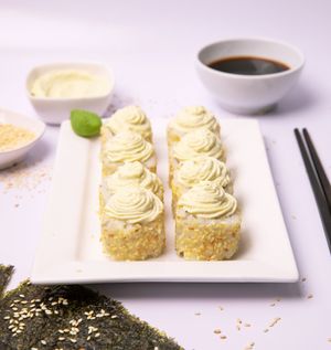 Vegan Cream Cheese Sushi.
White rice with avocado and crispy cucumber rolled in a seaweed sheet with cream cheese topping.  at Dobro Top Vegan   in Dubai