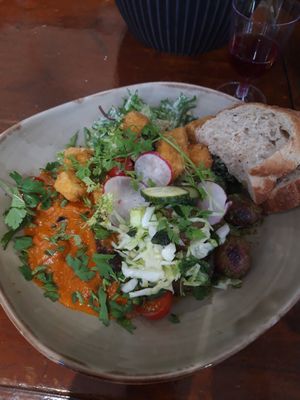 Saturday brunch plate with fried tofu bites, caesar salad, pesto potatoes and giant beans and eggplant on a bell pepper sauce with salad, greens and pea spread. Heavenly! at Ravintola Lohtu in Helsinki
