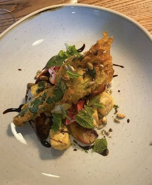 Tofu stuffed fried courgette flower with roasted peach, crispy tofu & seeds   at Lovage  in Newcastle Upon Tyne