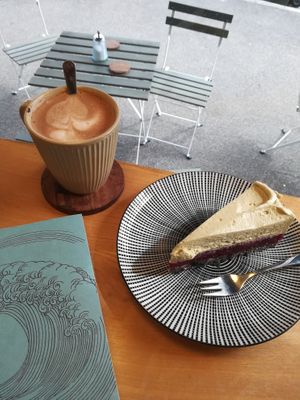 Belgische heiße Schokolade (Zartbitter mit Hafermilch) und Kuchen mit Mohnboden, Waldbeerkompott und Pistazien-Sojasahne-Creme at Pustekuchen in Ludwigsburg