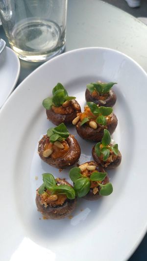Marinated mushrooms filled with red pesto, topped with pine nuts and mini basil leaves at COR in Zurich