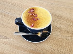 House Turmeric Latte w/ organic rose petal at Jing Si Books & Cafe  in Salisbury
