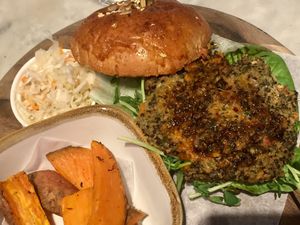 Quinoa Veggie Burger. Comes with sides of coleslaw and sweet potato wedges. The patty is a blend of natural food. All ingredients are visible and recognizable.  at The Living Cafe in Central Singapore
